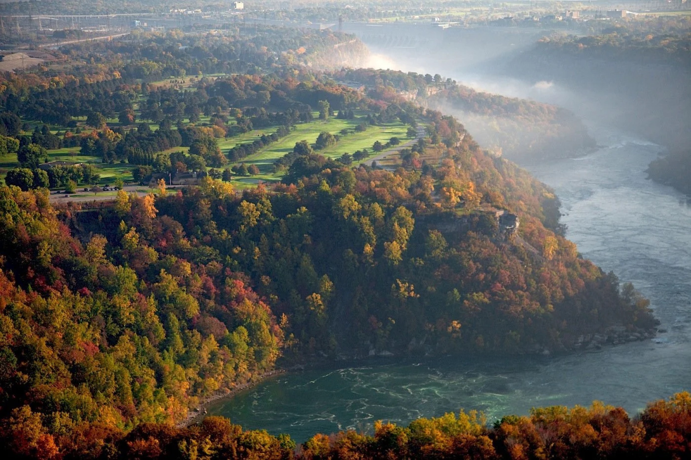 Aerial view of the Niagara gorge at dawn with Whirlpool Golf Course carved into the treeline
