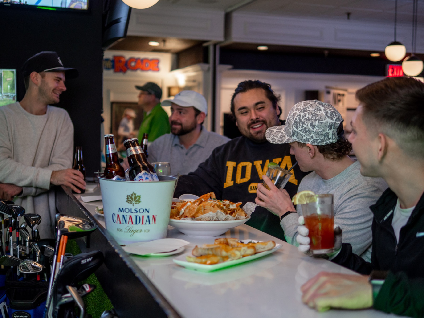 A group shares a bucket of beers and appetizers at the lounge bar