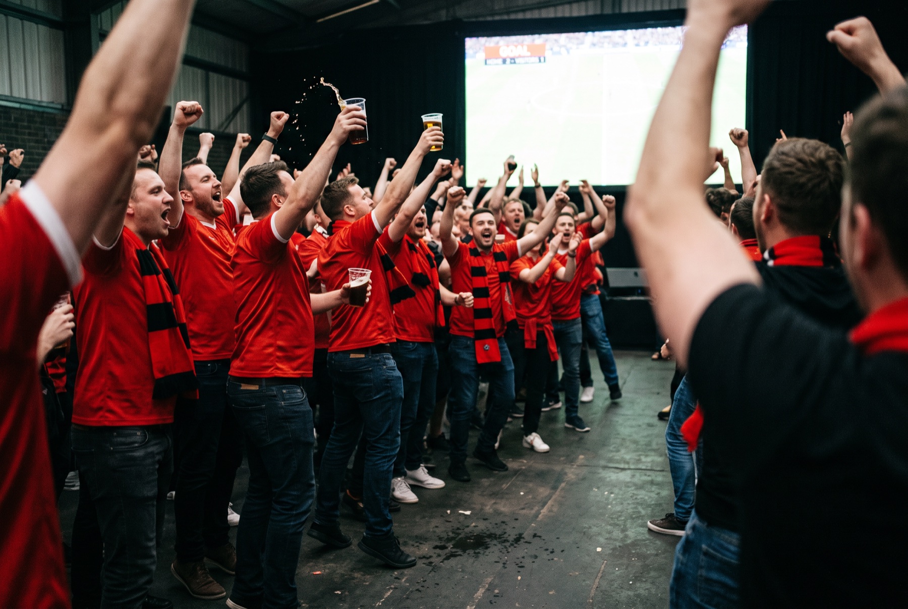 Supporters in red erupt as a goal goes in on the big screen