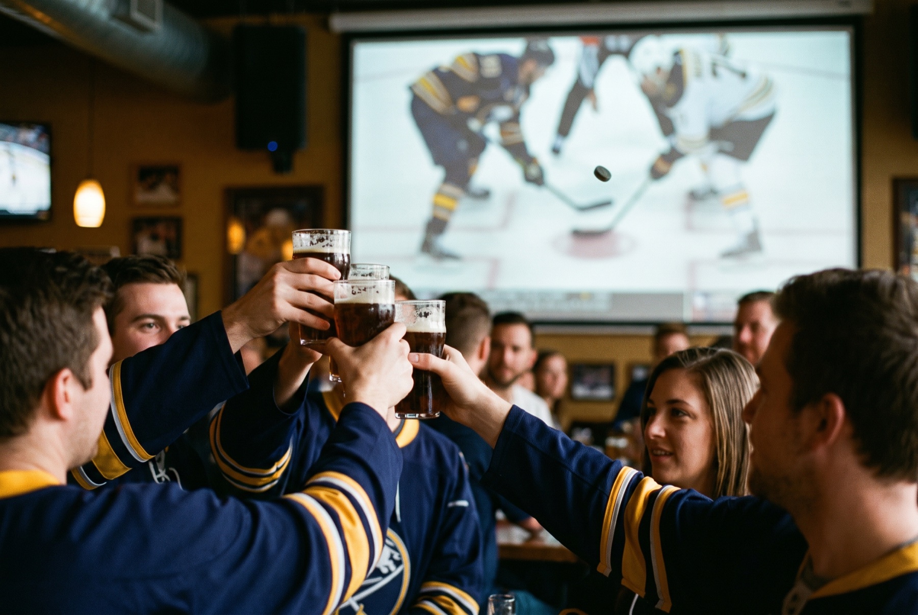 Hockey fans in navy and gold raise a toast at puck drop