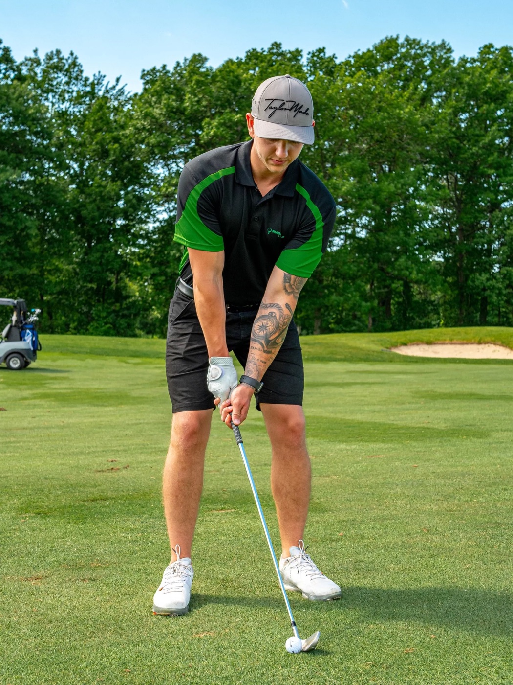 A golfer in Niagara Golf Lounge colours addresses the ball on a summer fairway