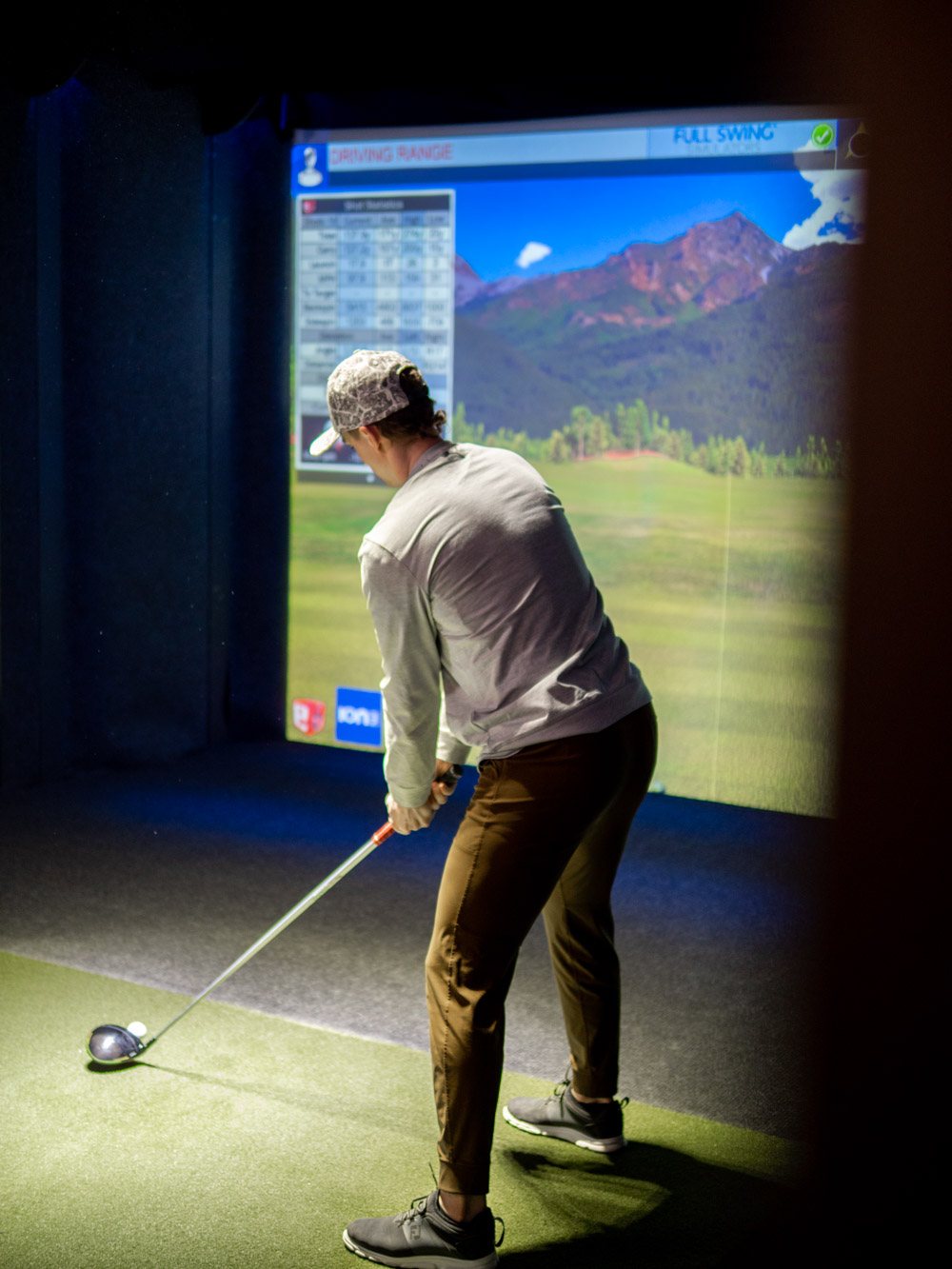 A league player follows through on a drive inside the simulator bay
